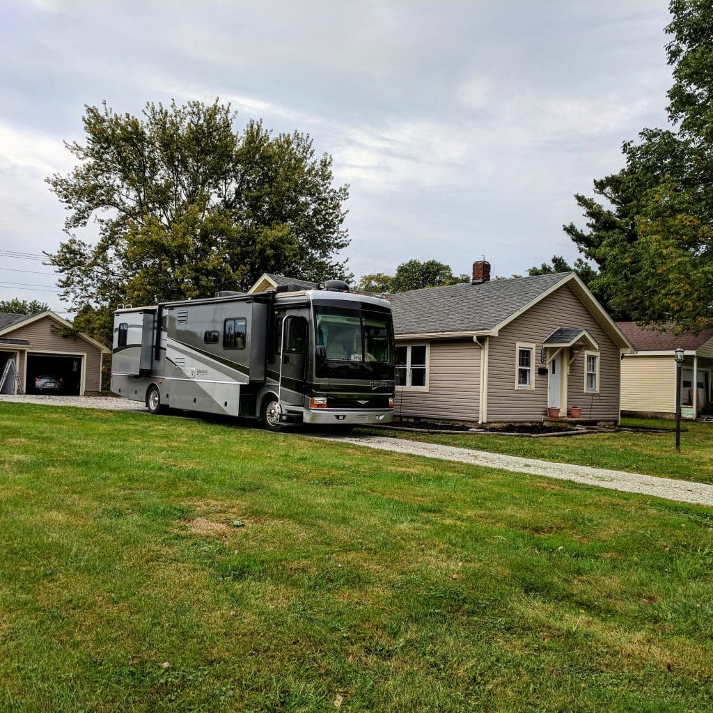 About The Diesel Apartment 3 green motorhome parked next to a brown house